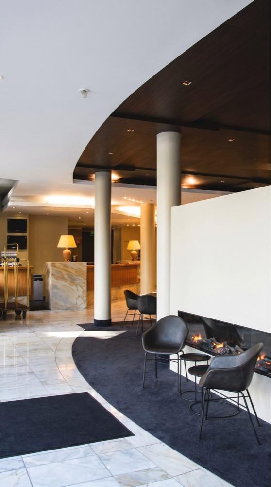 Öffentlicher Hotelbereich mit warmer Beleuchtung und Sitzbereich.